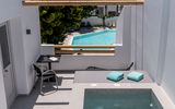 Private Terrasse mit Pool, Sonnenliege und Sitzgelegenheit – Blick auf den gemeinschaftlichen Pool und die umliegende Berglandschaft für entspannte Urlaubsmomente in ruhiger Atmosphäre.