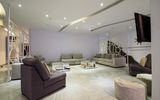 Großer Lounge-Bereich mit bequemen Sofas, modernen Raumteilern und stilvollem Deckenlicht – ideal zum Entspannen oder Lesen.