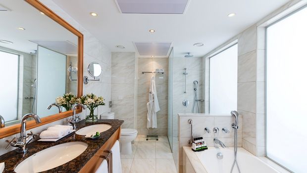 Helles, elegantes Bad mit Doppelwaschbecken, moderner Dusche und einladender Badewanne für entspannte Momente.