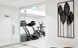 Modern ausgestatteter Fitnessraum im Costa Grand Resort & Spa mit Laufbändern und Ergometern – stilvolles, lichtdurchflutetes Ambiente mit Glaswänden und minimalistischer Dekoration.
